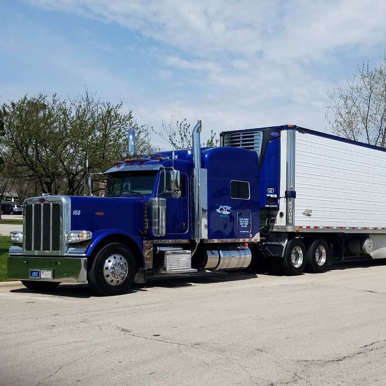 Royal blue Peterbilt tractor coupled to a CST Lines refrigerated trailer